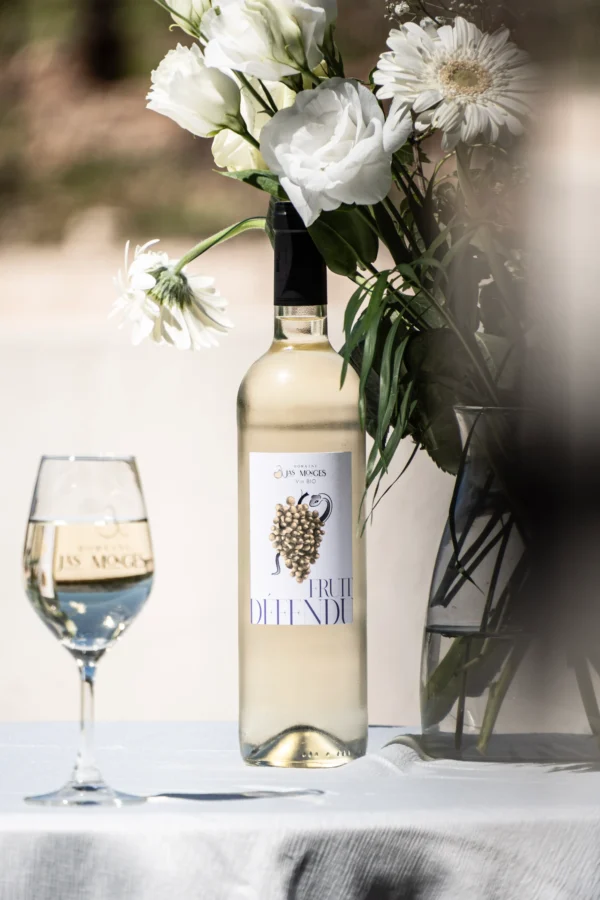 IGP Méditerranée blanc photographié au printemps, à coté d'un bouquet de fleurs blanches, au domaine Jas Monges